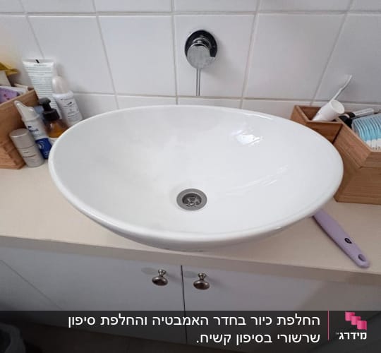 כיור לבן עם ברז בחדר אמבטיה